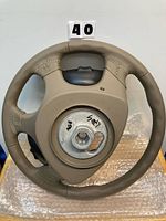 Front view of tan Jaguar steering wheel, hub cover on