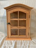 Front view of oak wood cabinet with glass door closed