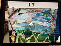 Full view of stained glass panel showing sailboat, flowers, vines and hanging chain