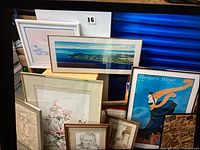 Group shot of assorted framed wall art leaning against blue door