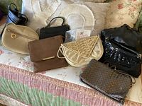 Group shot of seven handbags on sofa