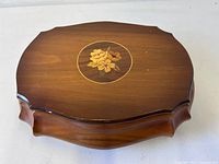 Top view showing wood grain, scalloped shape and floral marquetry inlay