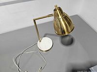 Full view of brass desk lamp on marble base with cord