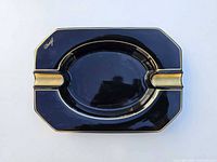 Top view of black porcelain ashtray with gold trim