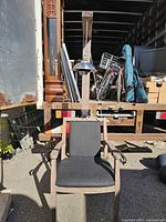 Front view of electric chair replica showing upholstery, arm straps, and lamp