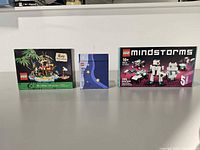 Front view of three LEGO set boxes on table