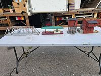 All four Lionel structures on table: bridge, station, water tower, industrial building