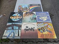 All eight LPs laid out on ground, showing front covers