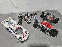 Top view of both RC cars with batteries, chargers, control modules