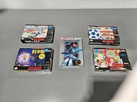 Front view of the five shrink-wrapped game boxes
