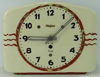 front view of enamel Art Deco wall clock showing dial and painted case