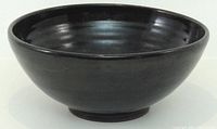 Side view of black stoneware bowl showing exterior finish and shape