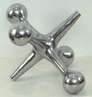 Front angled view of chromed brass jack showing three arms and reflective finish