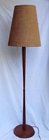 Full view of teak floor lamp with shade attached
