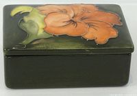 Lidded box angled view showing Hibiscus motif and dark green body