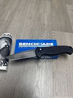 Knife open resting on original Benchmade box and leaflet