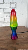 Full view of rainbow lava lamp on wooden surface