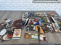 Wide view of all magazines, Wii games, loose DVDs, Beanie Baby books and pamphlets spread on table