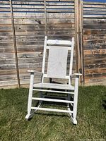Full view of white rocking chair on grass
