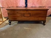Front view of cedar chest showing veneer, oval inlay, cabriole legs
