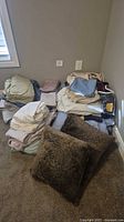 Piles of folded bedding, two brown faux fur pillows