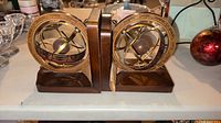 Front view of both bookends showing armillary spheres and wooden bases