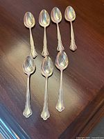 All six sterling silver demitasse spoons displayed bowl up