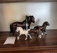 Group shot of all four ceramic horse figurines showing relative sizes and colours
