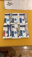 Six sealed Jobst compression stocking boxes laid out on table