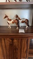 Two Beswick horse figurines on shelf