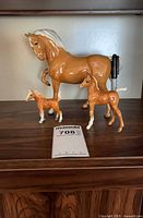 Full set of three ceramic horse figurines on shelf