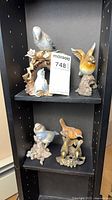 Shelf with four bird figurines displayed
