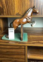 left side profile of ceramic horse jumping gate on felt base