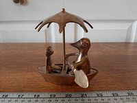 Front view of brass duck and frog figurine with ruler for scale