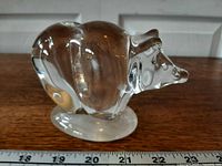 profile view of clear glass bear figure on base