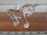 Profile view of clear glass donkey showing body and mane