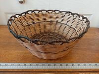 Top view of round wicker basket showing weaving pattern and scalloped rim