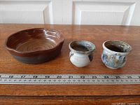 Serving bowl and two condiment bowls with ruler for scale