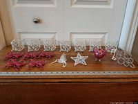 All ornaments lined on table: cubes, bows, hummingbird, star, elephant, rings