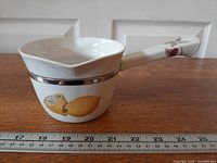 Side view showing lemon motif, platinum band and spout