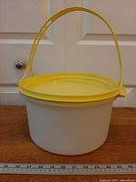 Full view of cake taker with handle upright, ruler for scale