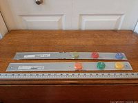 Two sealed Ikea BAR magnetic strips on table with ruler for scale