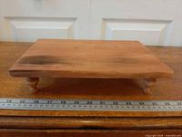 Top view of rectangular wooden riser with ruler for scale