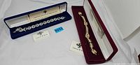 Both boxed Camrose & Kross bracelets with COAs visible