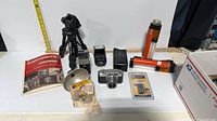 Overview of all items including camera, tripod, flashes, flashlights, battery pack, book