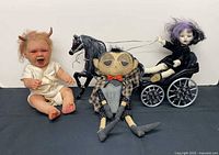 Group shot of three creepy dolls with horse and buggy
