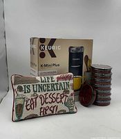 Boxed Keurig brewer, stacked wrapped ramekins, pillow front view