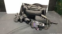 Olympus E-620 DSLR, Nikon Coolpix 990, large camera bag and small case displayed together
