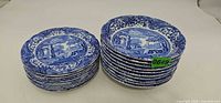 Stack of ten small plates and stack of ten cereal bowls with Spode blue and white pattern