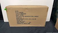 Front view of sealed Wolfgang Puck grill/griddle shipping box showing model and description text